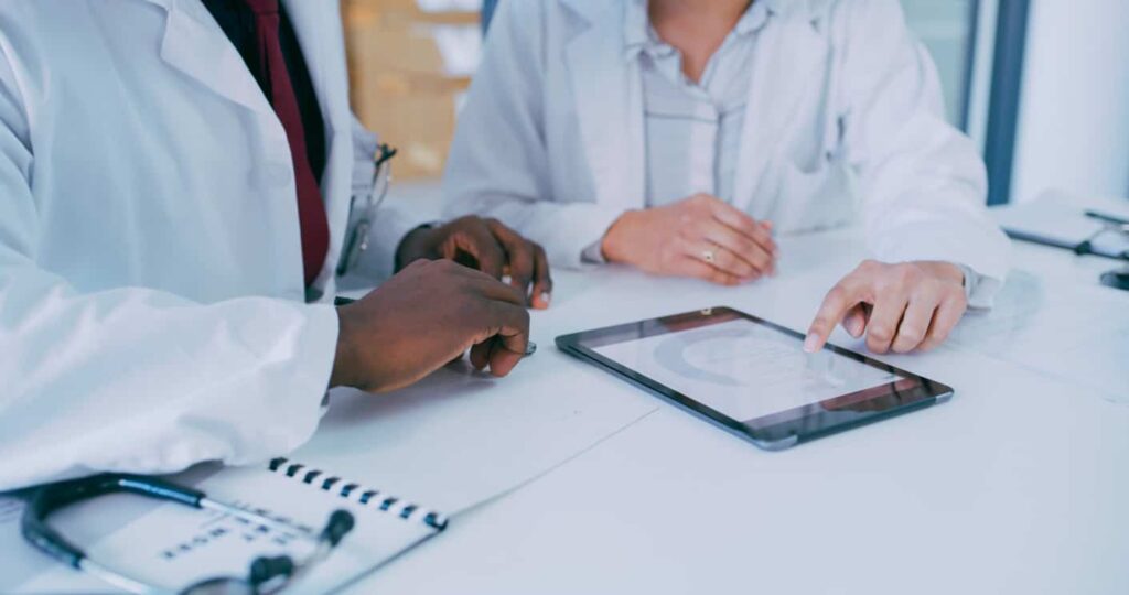 two doctors discussing with an ipad on the table